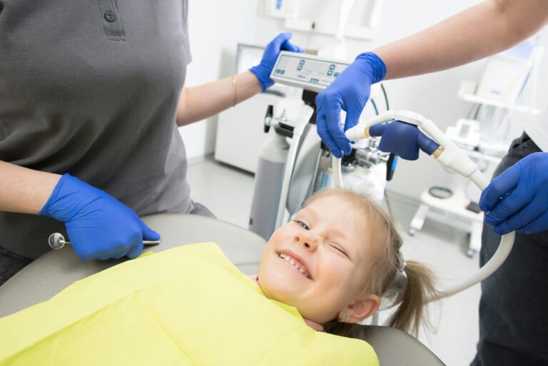 Smiling child receiving a pediatric dental checkup from a friendly dentist in a dental clinic