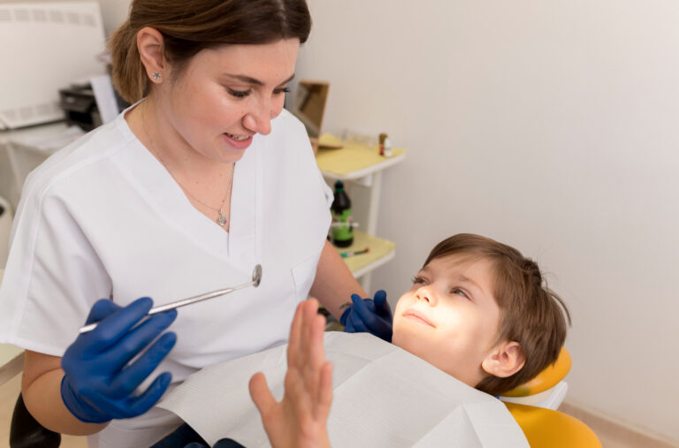 “Pediatric dentist examining a child during a children’s dental exam”