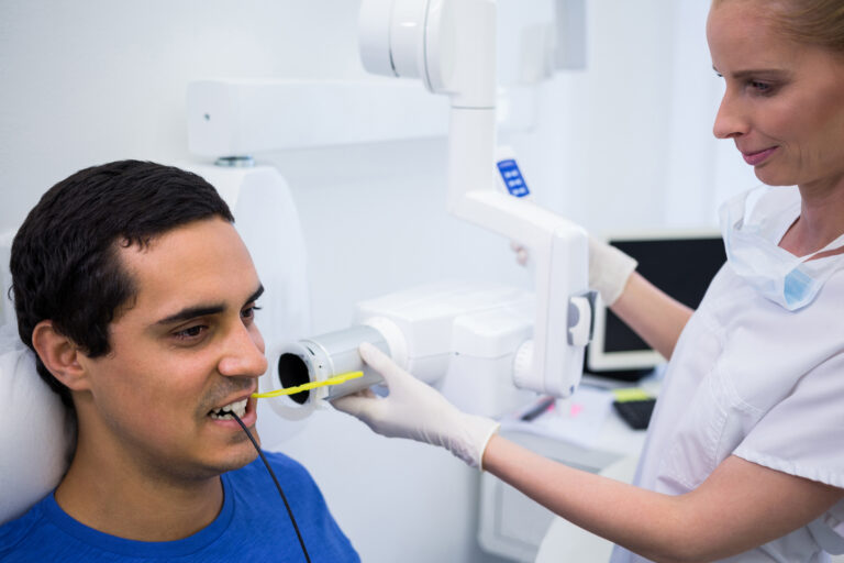 Dentist using dental laser safely with protective equipment during laser dentistry procedure